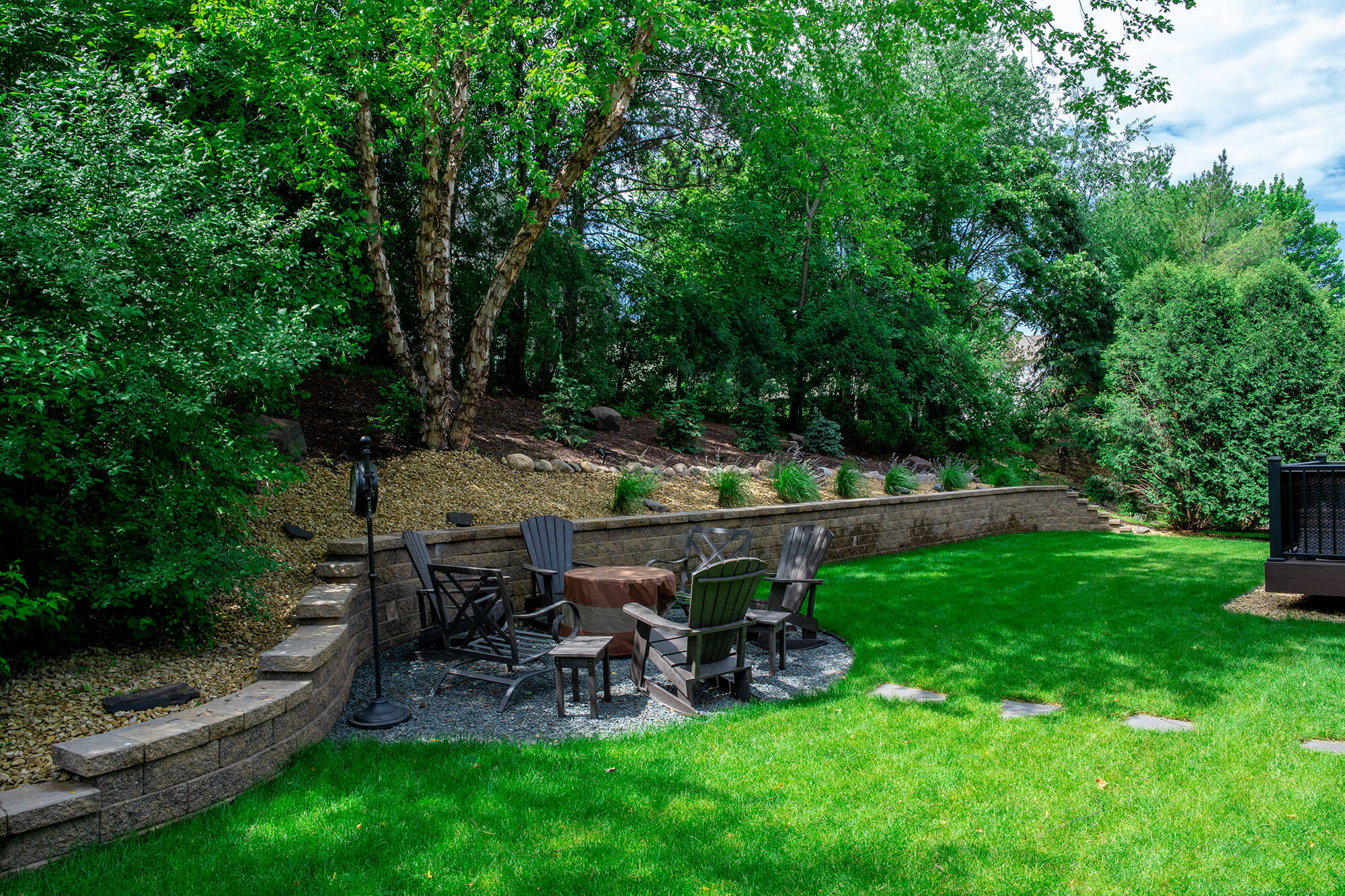 Backyard with retaining wall and seating area around a firepit