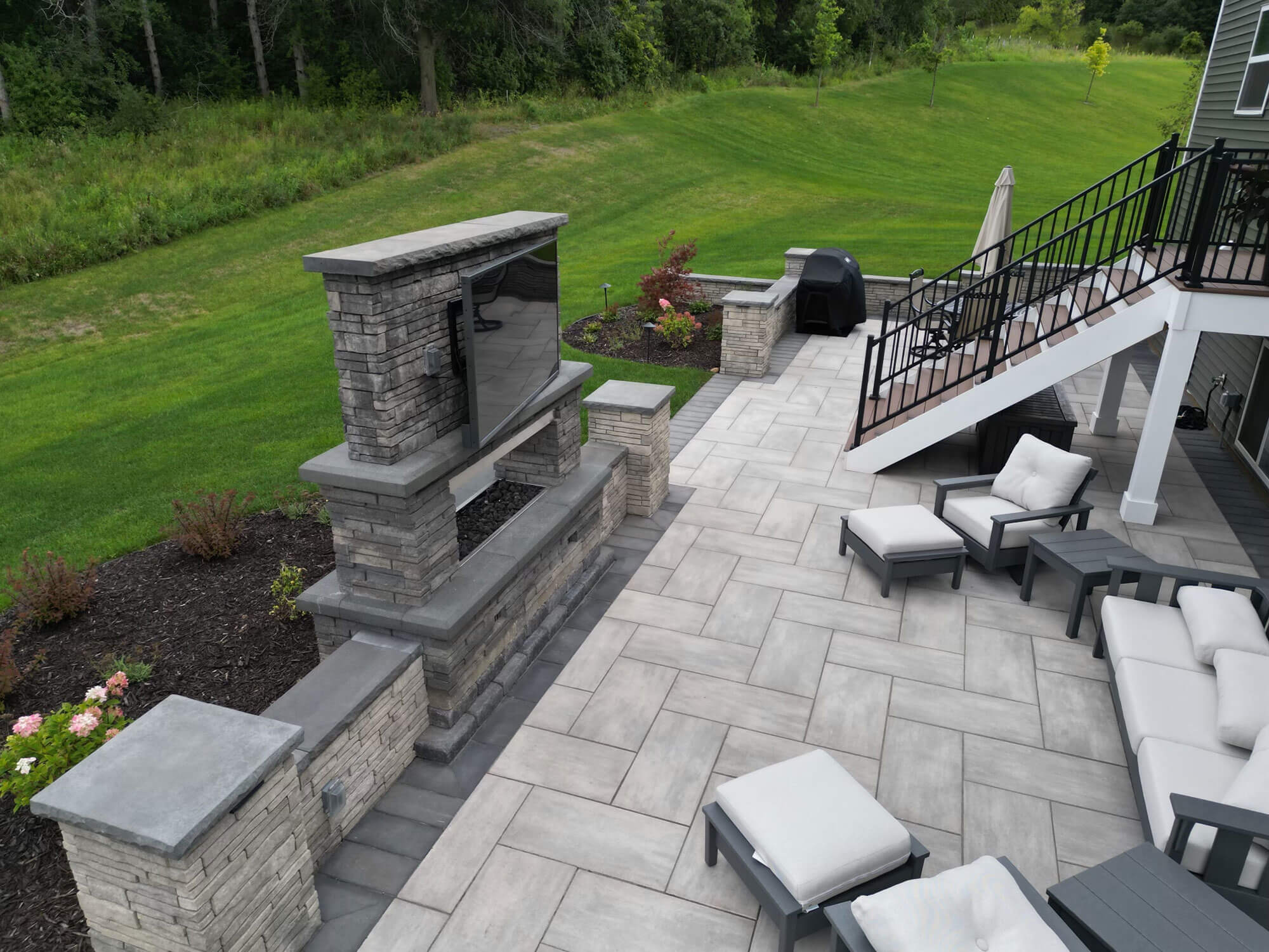 A well-designed outdoor living area with a patio, seating, and an outdoor entertainment setup