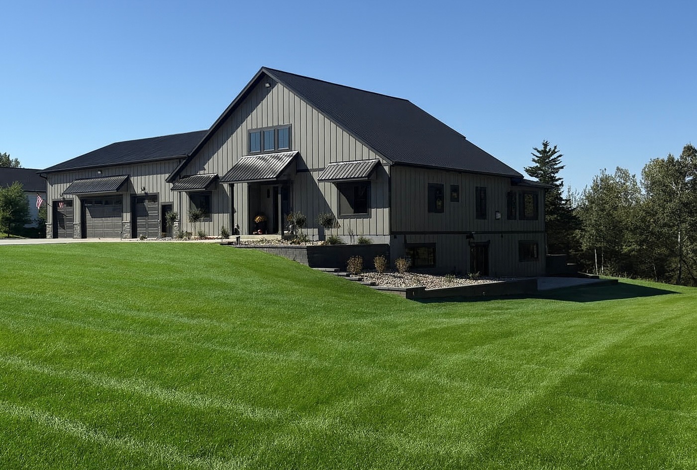 A lush green lawn in front of a modern home, showing a freshly maintained and healthy turf area.